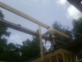 Carpenter setting a ridge beam over a new addition frame — Ice Dam Removal by Roofing Brothers in Granite City