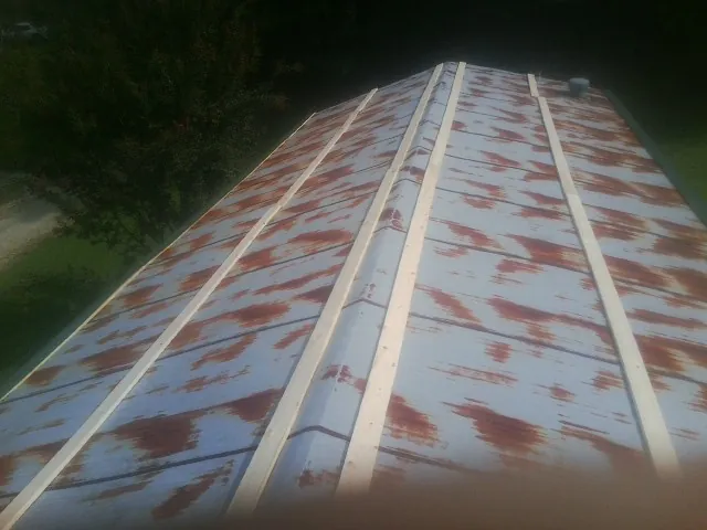 Rusted metal roof panels with new wood purlins before replacement — Storm Damage Roof Repair in Granite City by Roofing Brothers