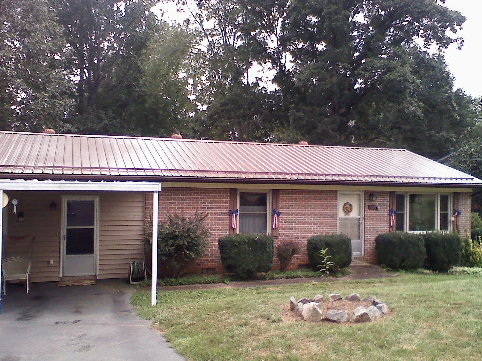 Bronze metal roof and carport on a brick ranch home — Roof Repair work by our crew in Granite City